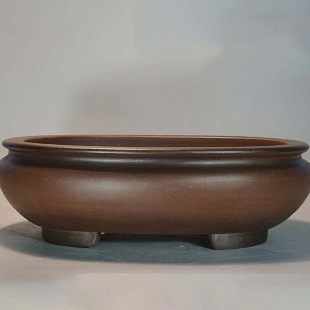 Handmade purple clay classical style desktop flowerpot on a wooden surface