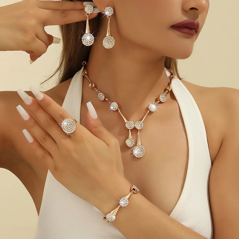Gold alloy necklace earrings and bracelet set with bow and fan motifs on a light background