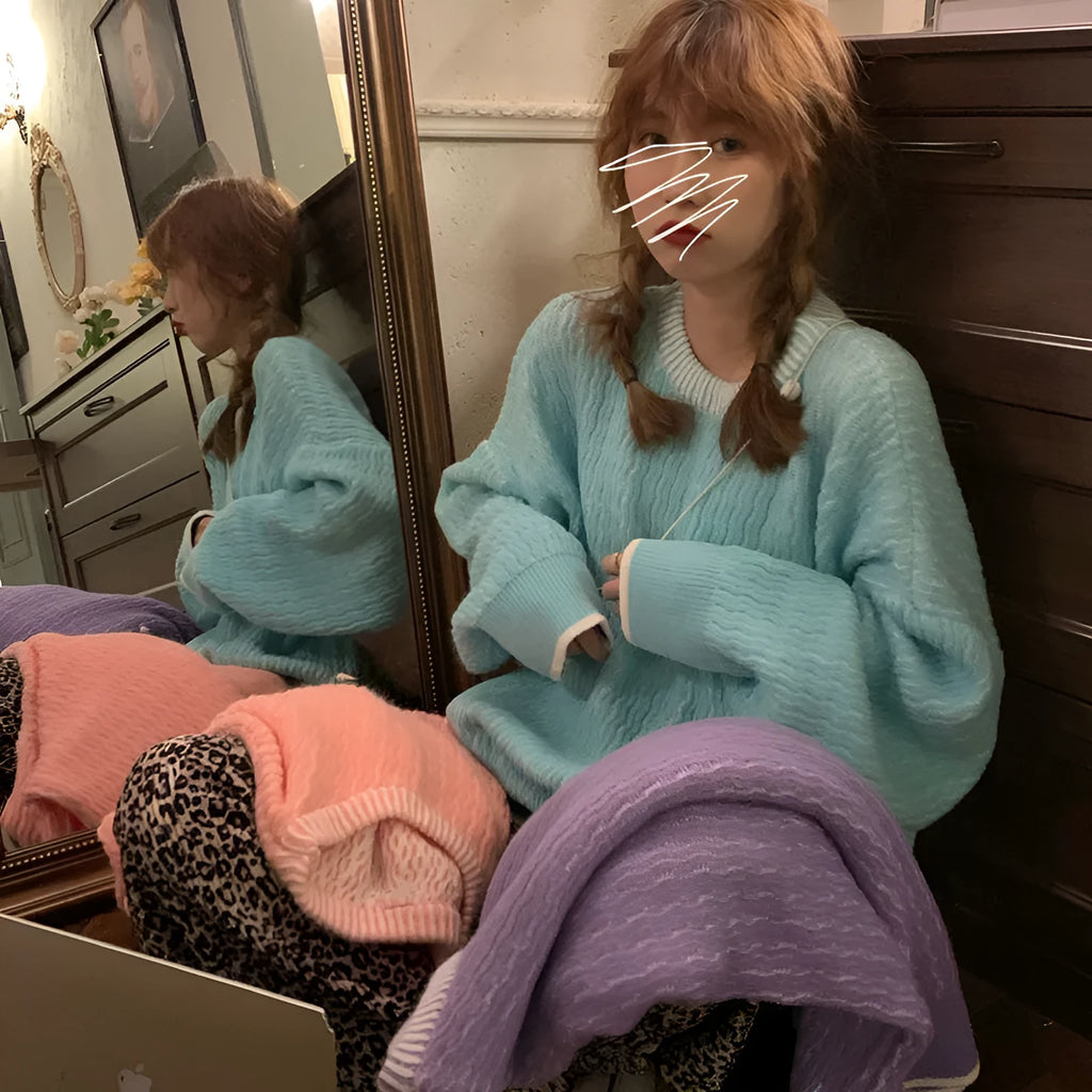 A woman's loose-fitting, solid-colour pullover sweater with regular sleeves, shown in lake blue.