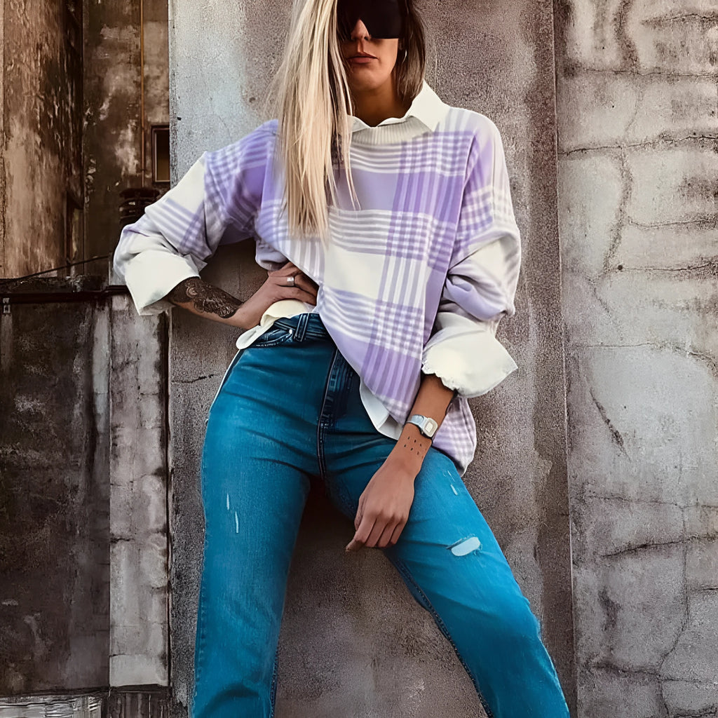 Lilac plaid print loose women's sweater with ribbed collar and cuffs on a hanger.