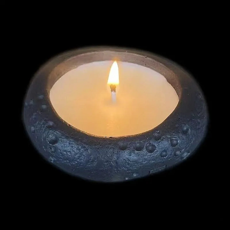 White cement candlestick ornament with fair-faced finish holding a candle