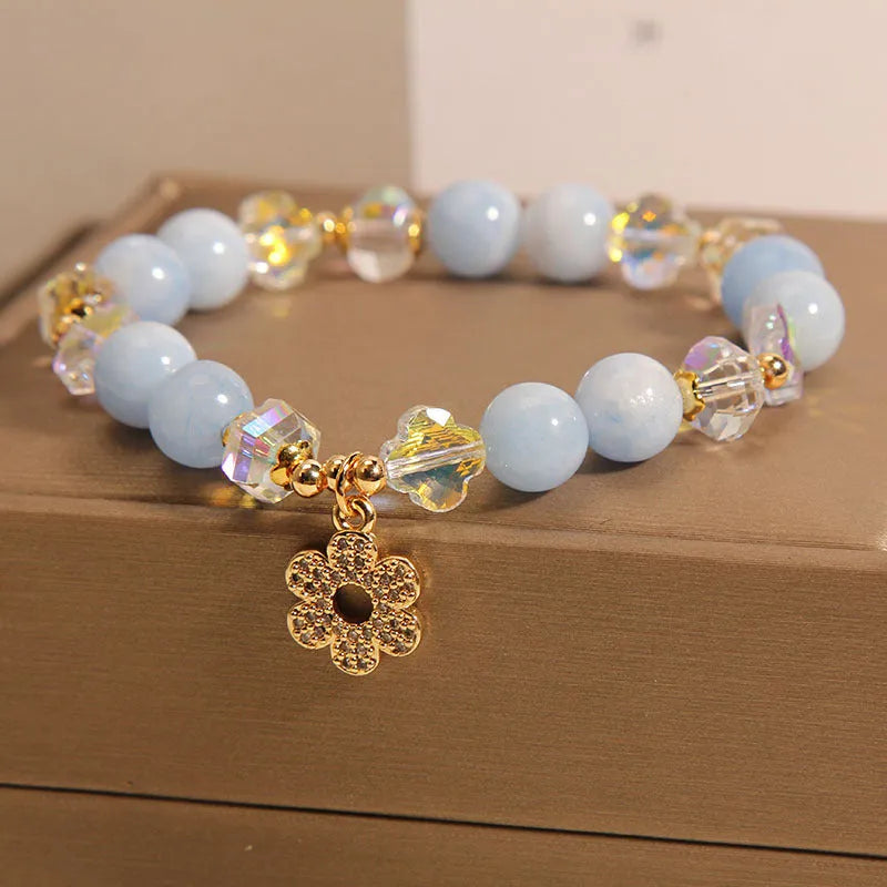 Women's aquamarine crystal bracelet with four-leaf clover design and a pearl accent.