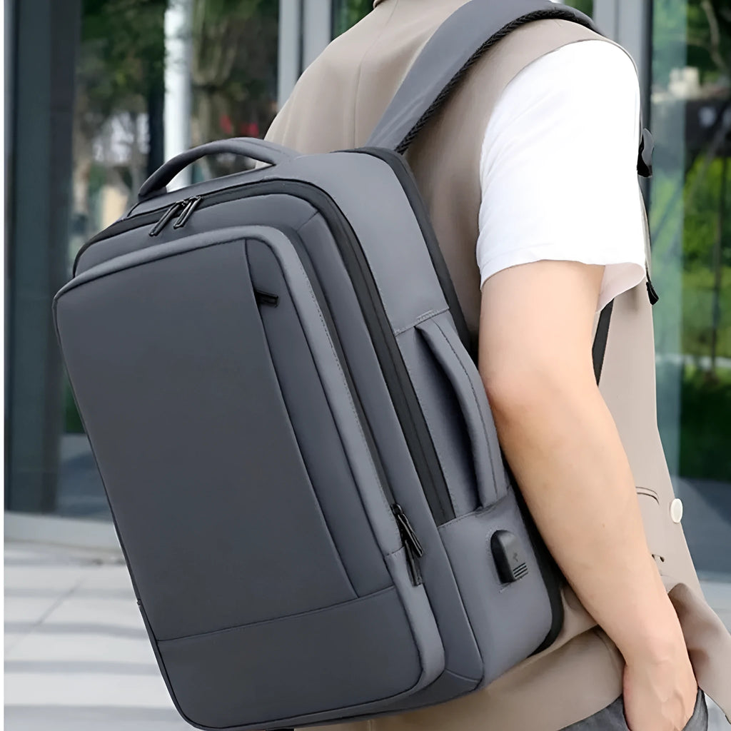 Black or grey large waterproof oxford cloth backpack with curved shoulder straps.