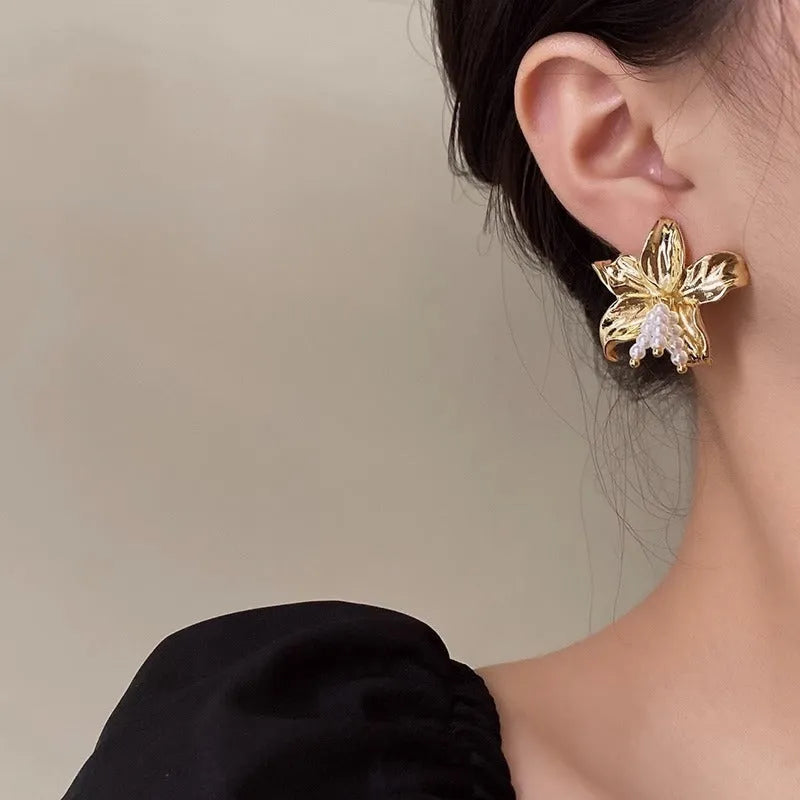 Golden metal flower earrings with exaggerated design and personalised pearl elements