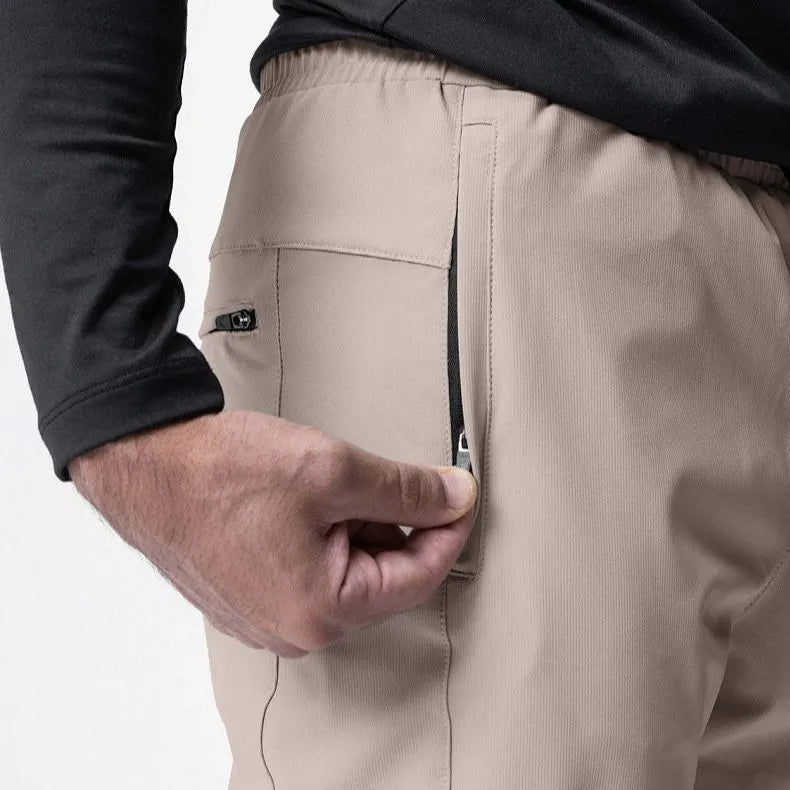 Male model wearing dark grey loose-fit fitness trousers with ankle ties.