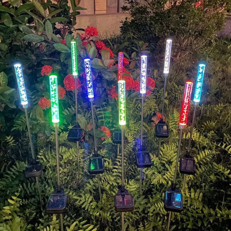Solar bubble stick lawn lamp with colourful slow-flash crystal effect and warm light on a garden lawn