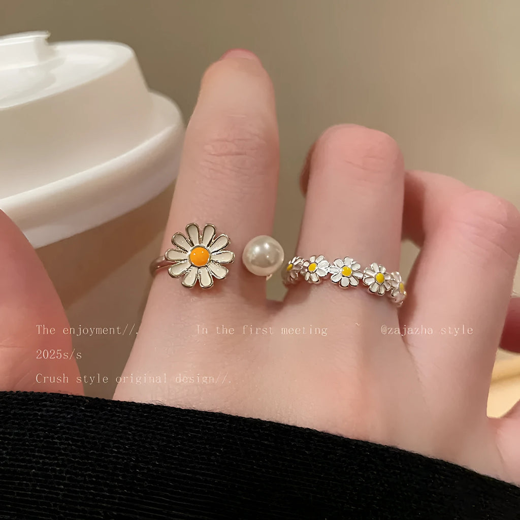Women's copper opening ring with floral daisy charm and pearl accents on finger