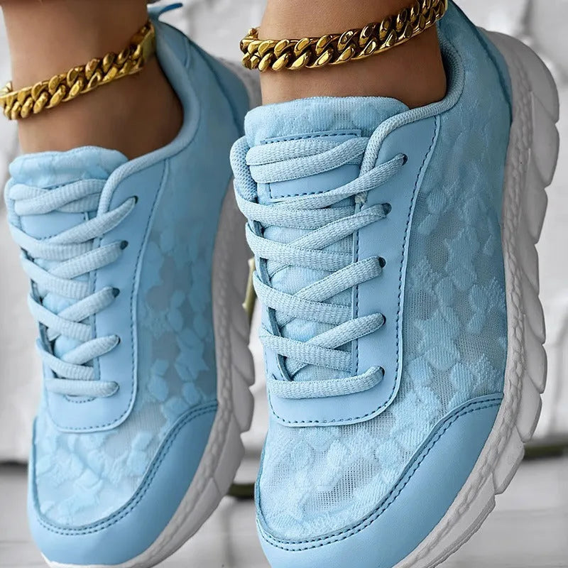 Women's white canvas running shoes with a round toe, flat heel, and soft sole on a neutral background.