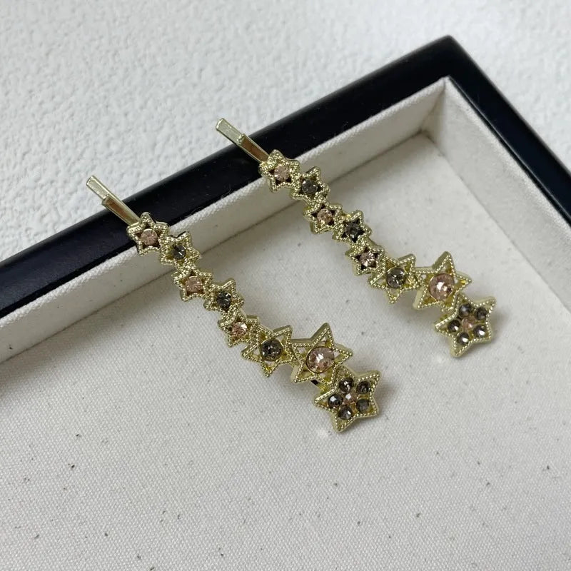 Gold-coloured alloy hair barrette with a rhinestone five-pointed star, shown as a side clip.