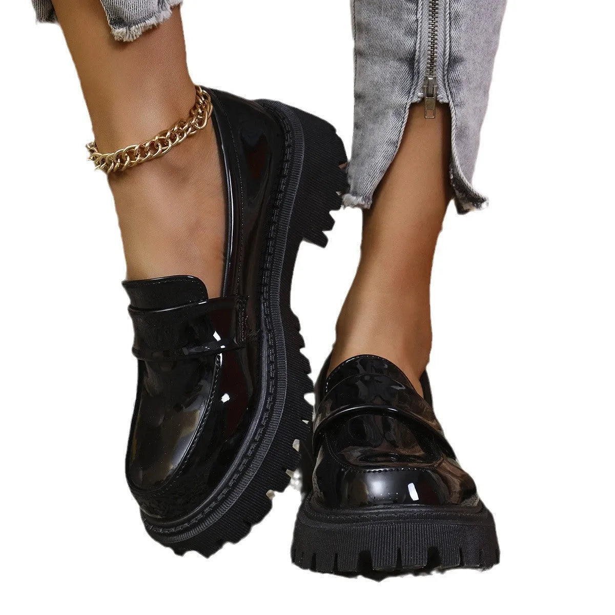 Women's black slip-on loafers with a chunky platform heel and rubber sole, shown from the side.