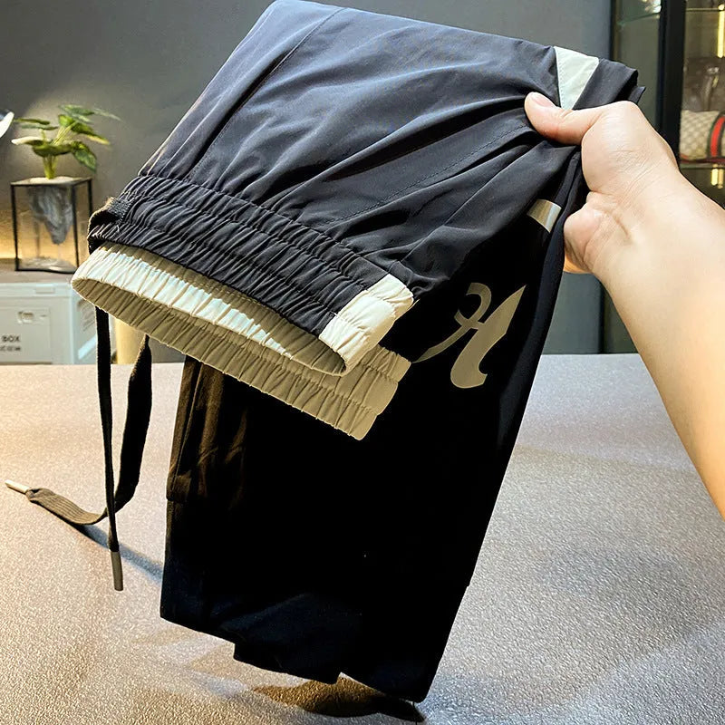 Men's black ultra-thin ice silk ankle banded cropped trousers on hanger