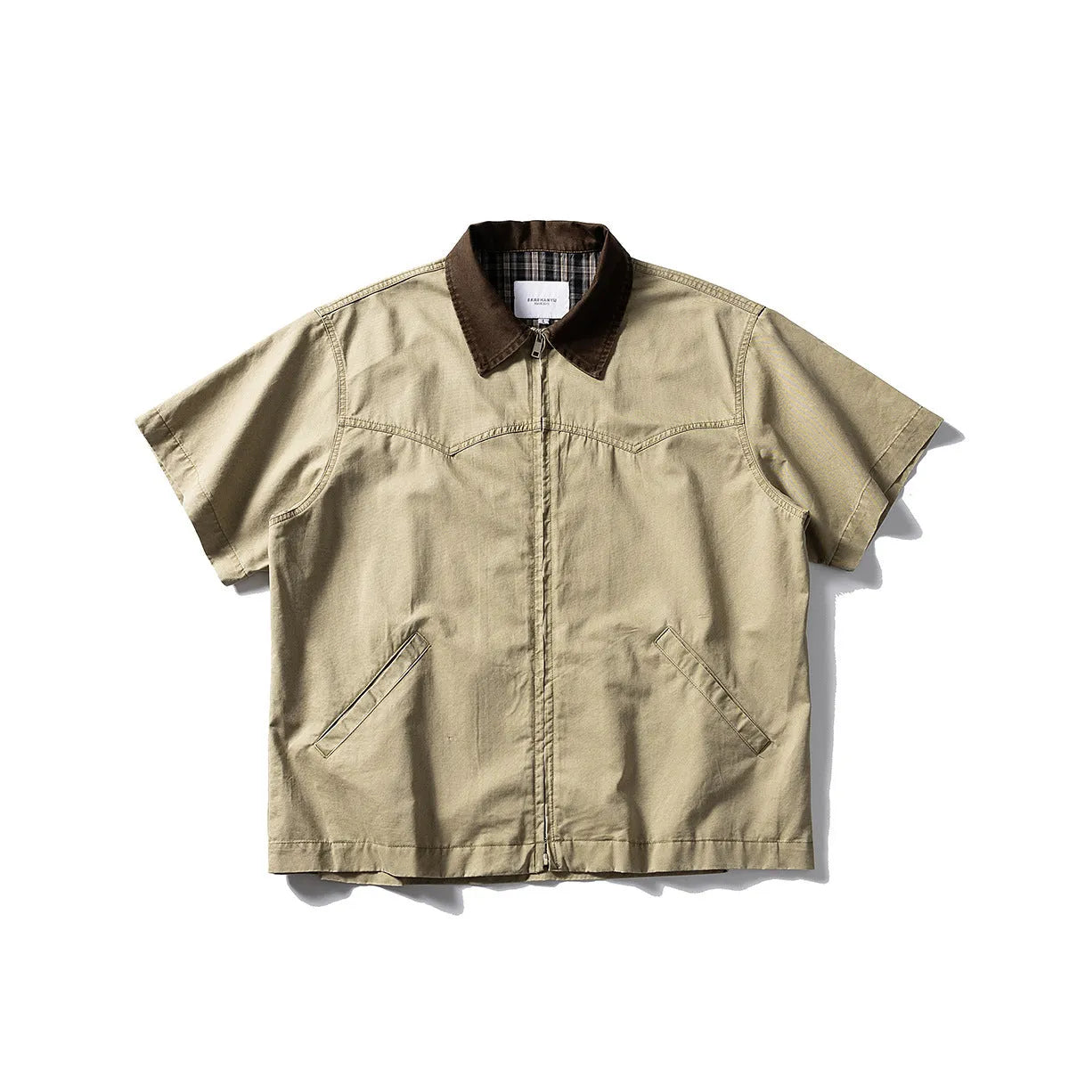 A khaki washed cotton overalls shirt with short sleeves and a loose cardigan style, laid flat.