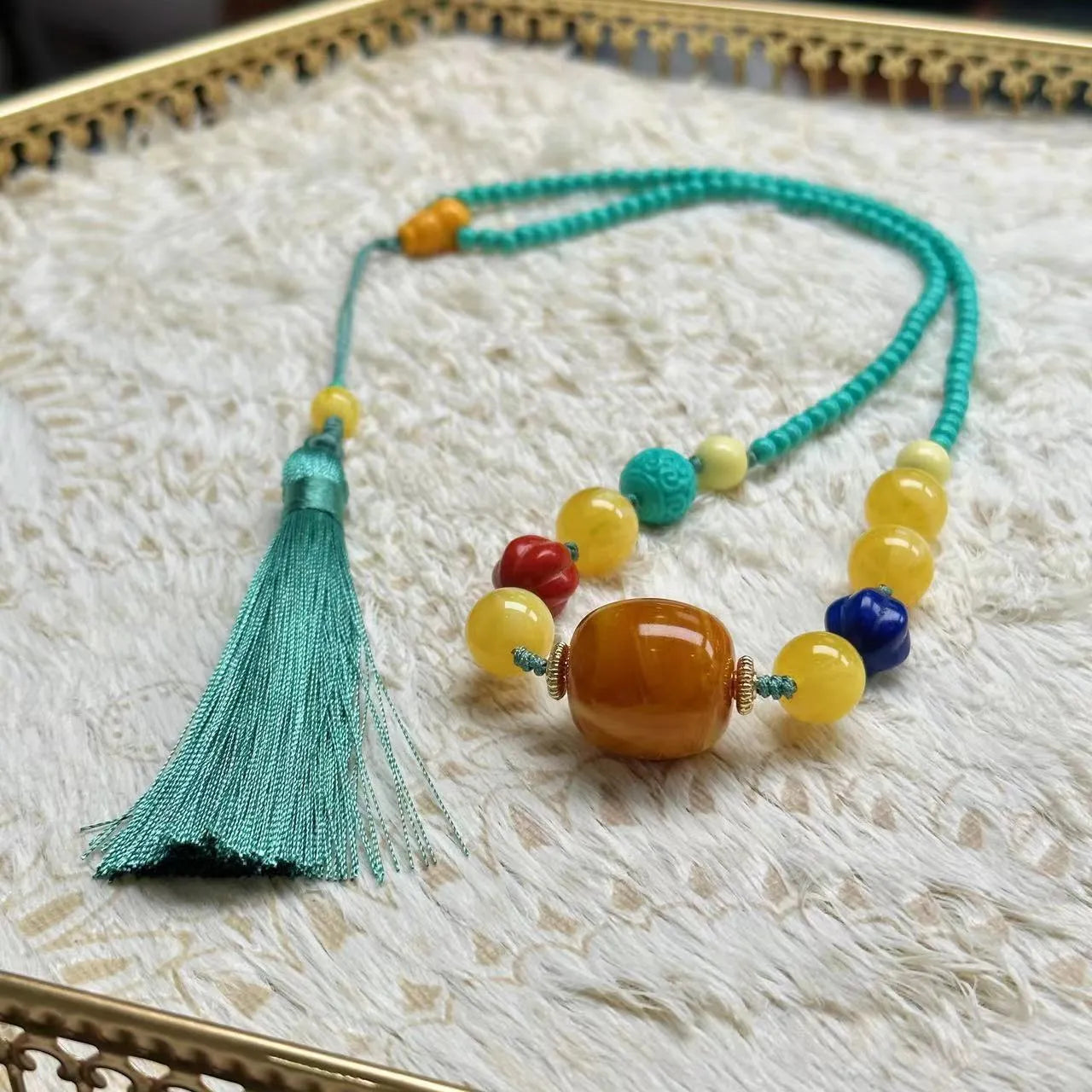 Turquoise ball bead necklace with a hand-woven mesh flower lucky pendant in stone.