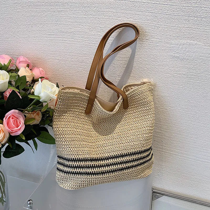 Large striped straw woven handbag with 64cm shoulder strap and polyester lining, shown in khaki or black