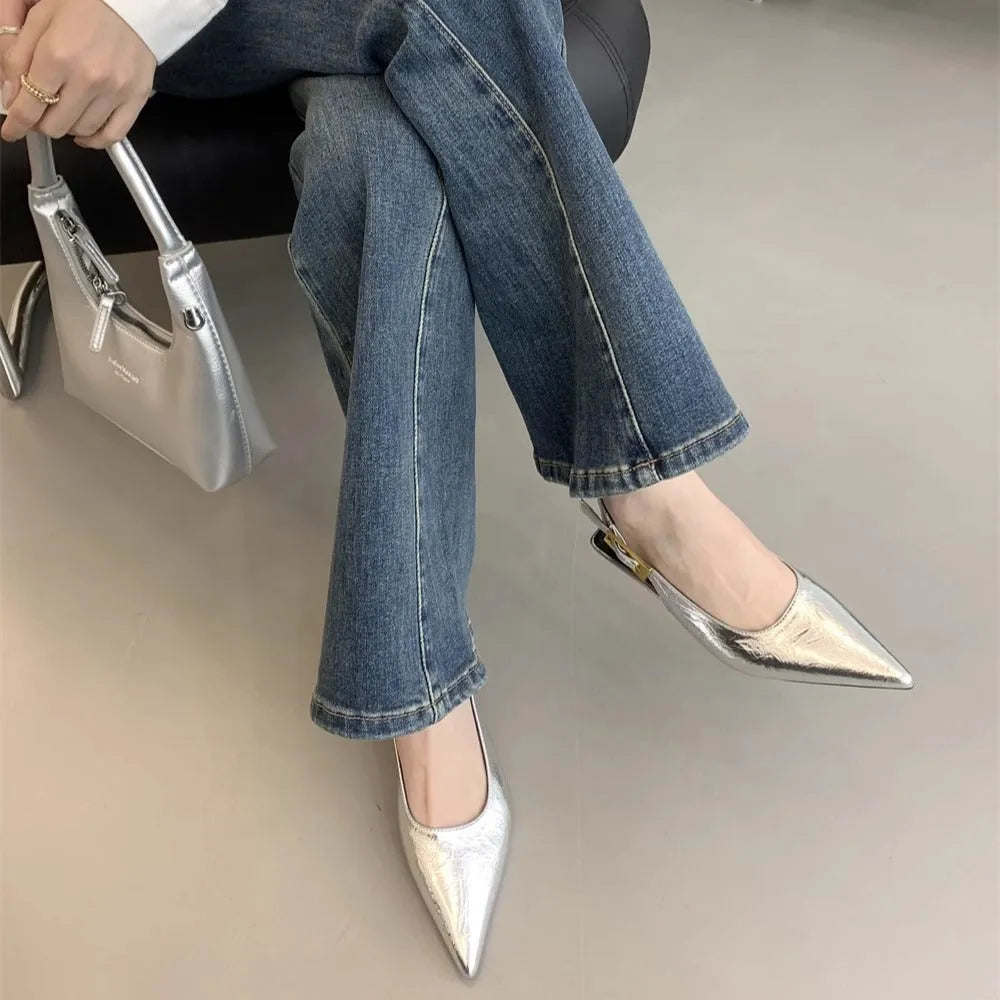 Women's black pointed toe low heel shoes with an ankle strap and rubber sole.