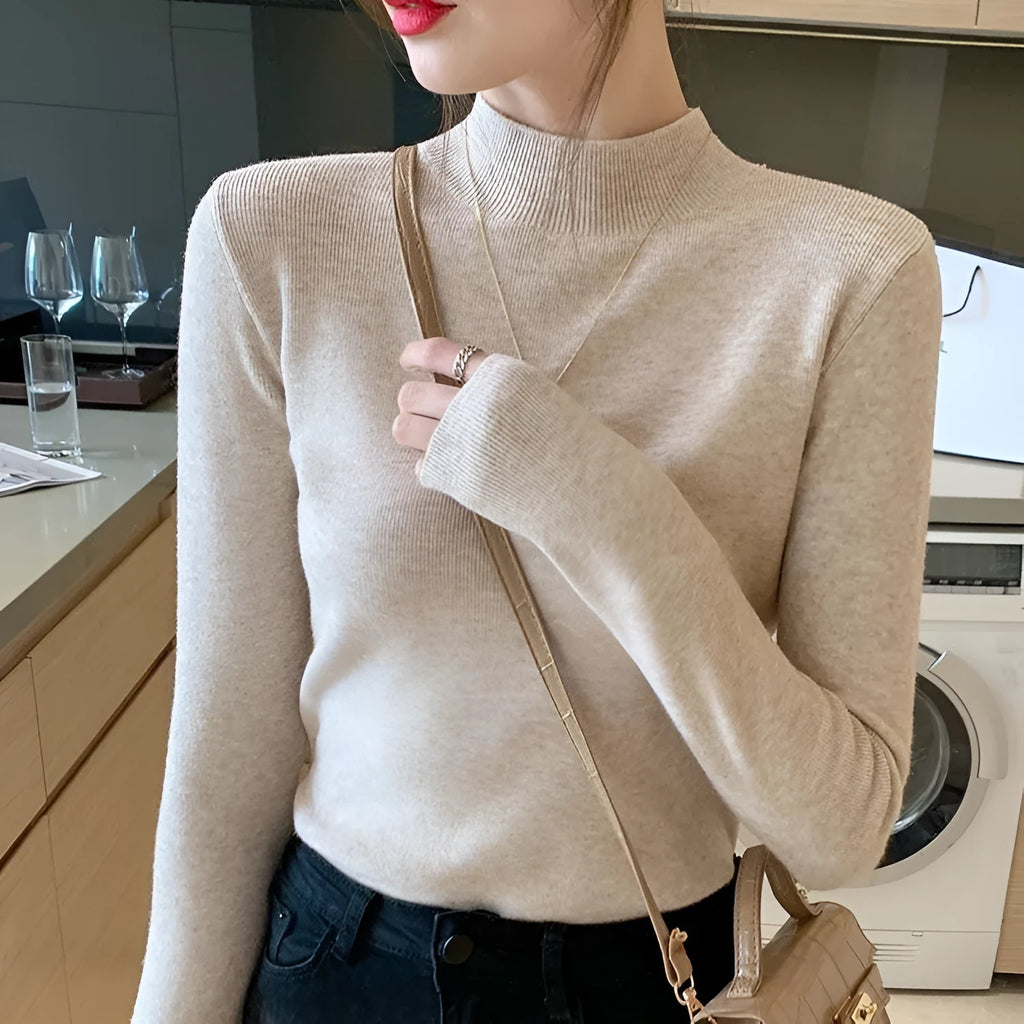 Slim fit apricot coloured viscose knitted long sleeve pullover shirt on a hanger.