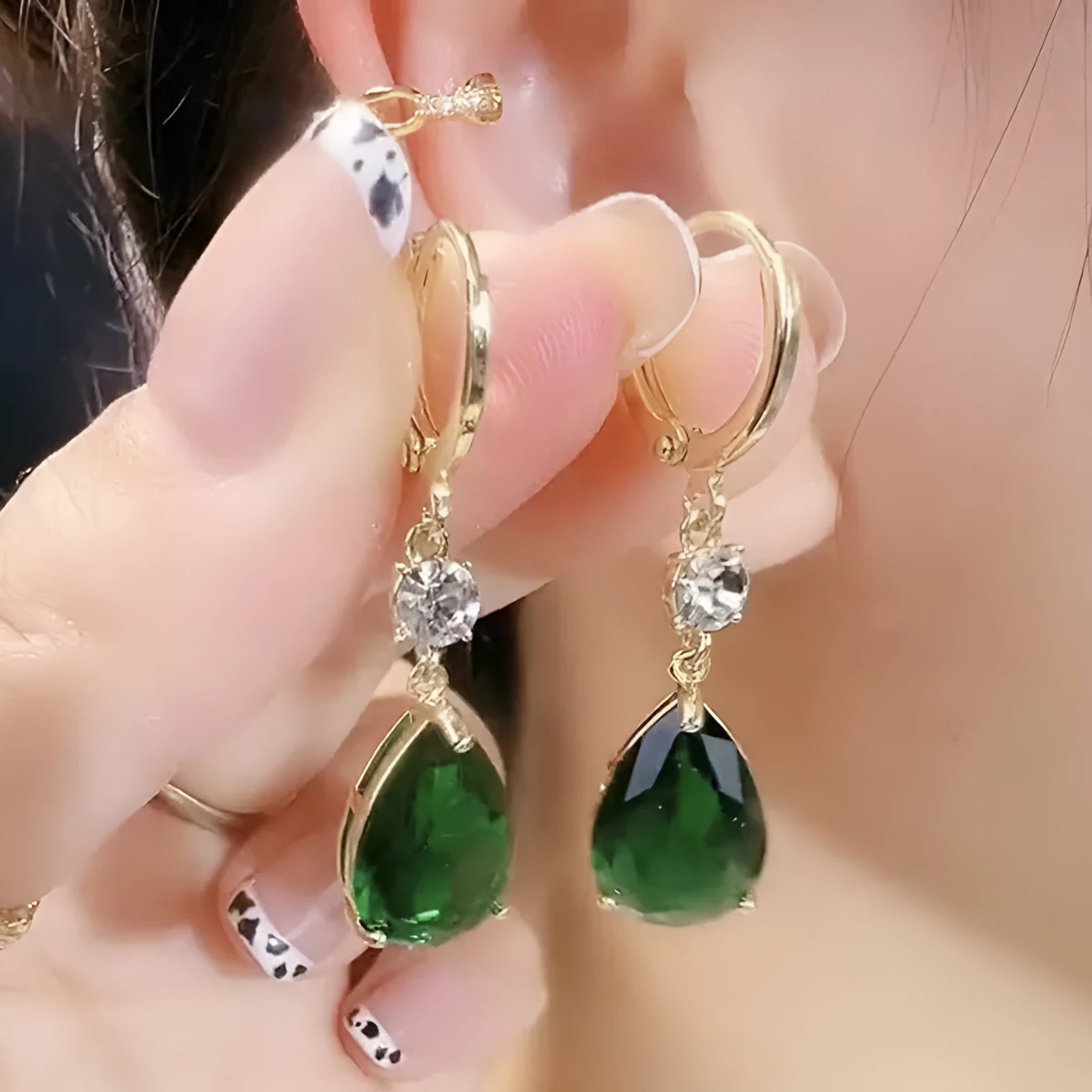 Pair of green geometric teardrop-shaped alloy earrings on a white background.