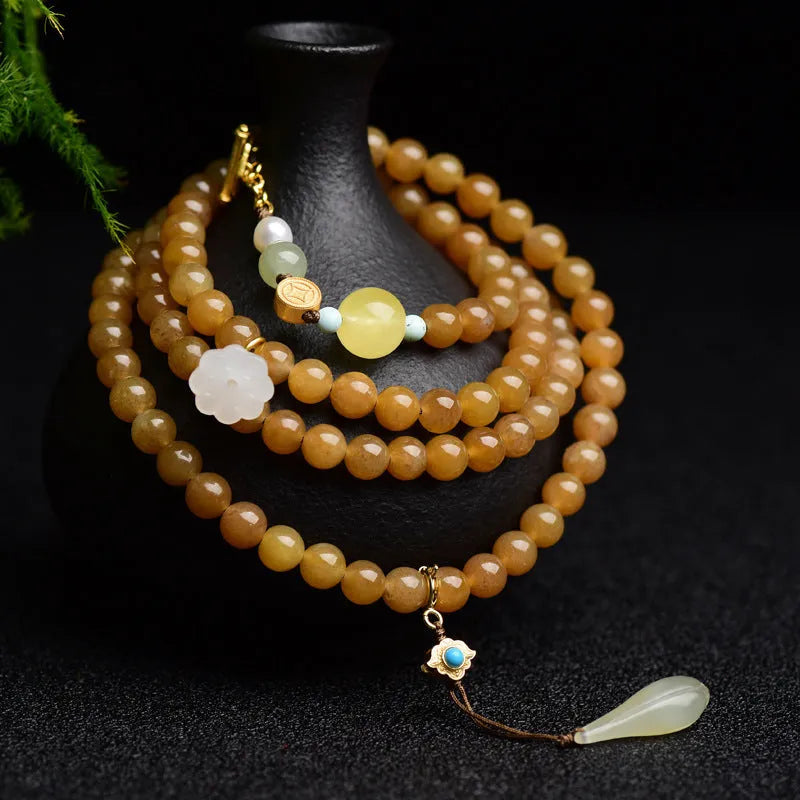 Women's jade bracelet with 6mm round beads showing clear water green pine pattern and leaf sequin accents