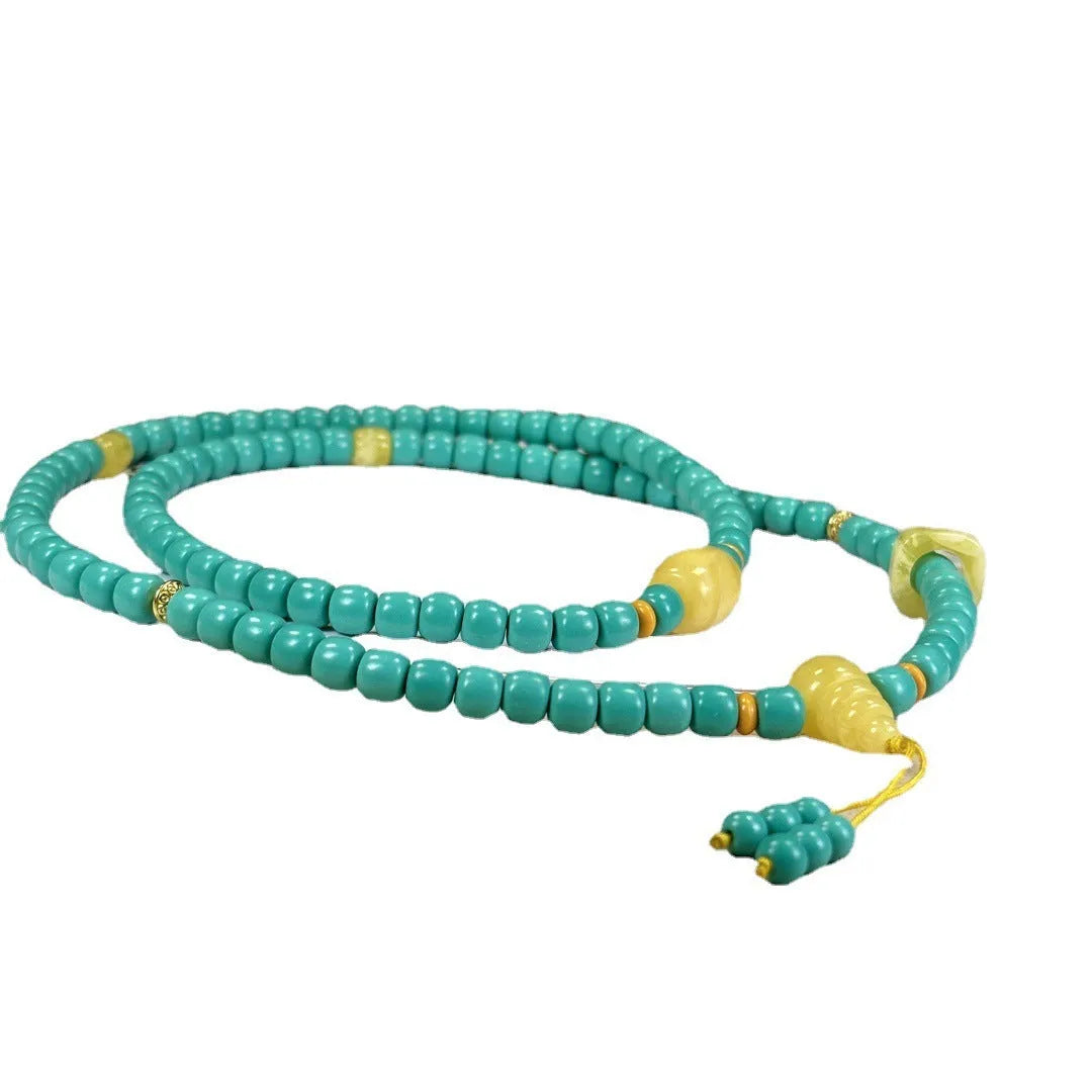 Turquoise ball bead necklace with a hand-woven mesh flower lucky pendant in stone.