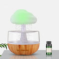 White rain cloud design desk humidifier and aromatherapy diffuser with mushroom-shaped night light on a wooden table.