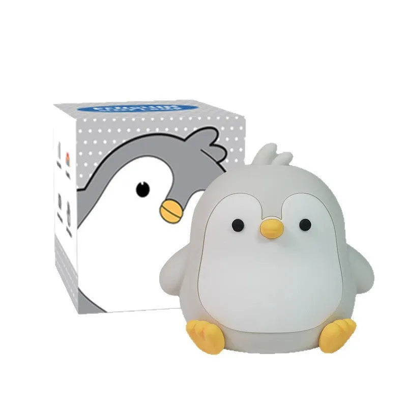 Baby penguin silicone small night lamp in black with warm light mode on bedside table