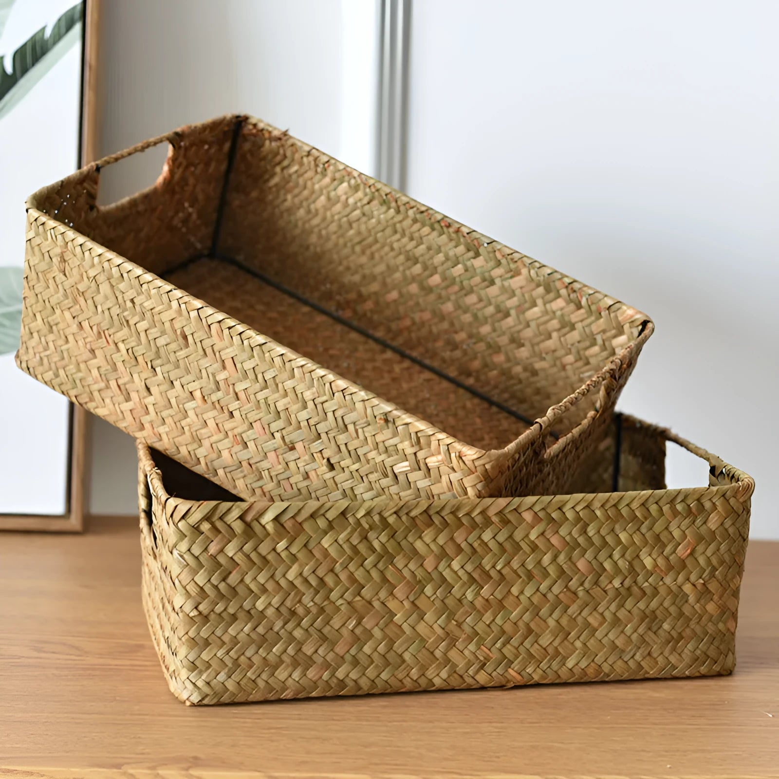Handwoven grass rectangular storage baskets in various sizes on a wooden shelf