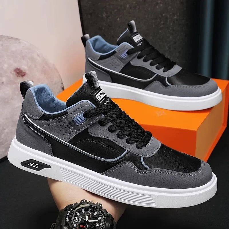 Men's low-top canvas shoes in grey with leather stitching detail on a white background