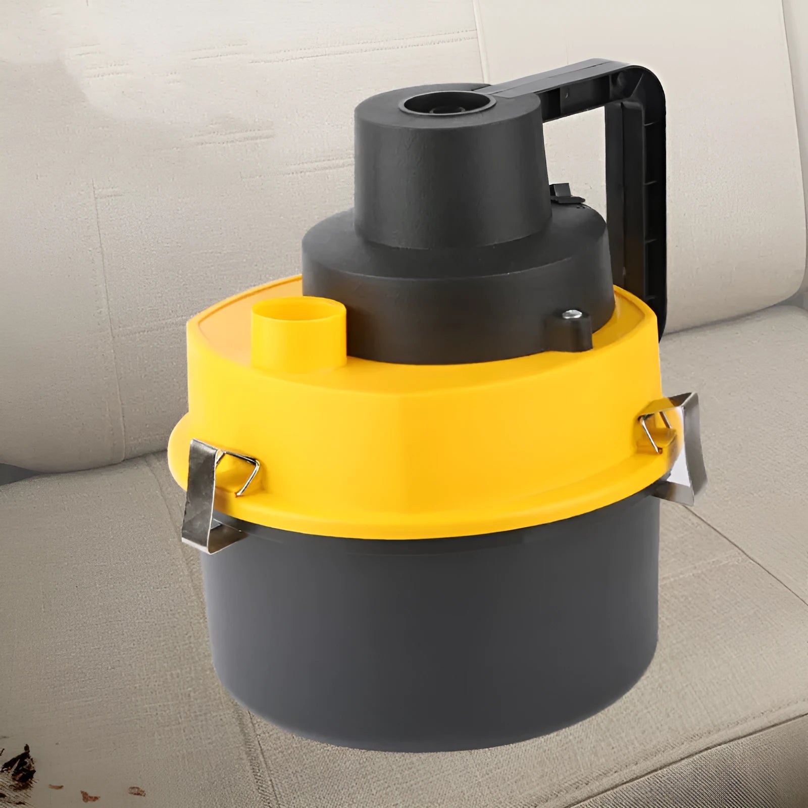 Yellow 12V wet and dry car cleaner with ABS body on a grey surface with nozzles and hose visible