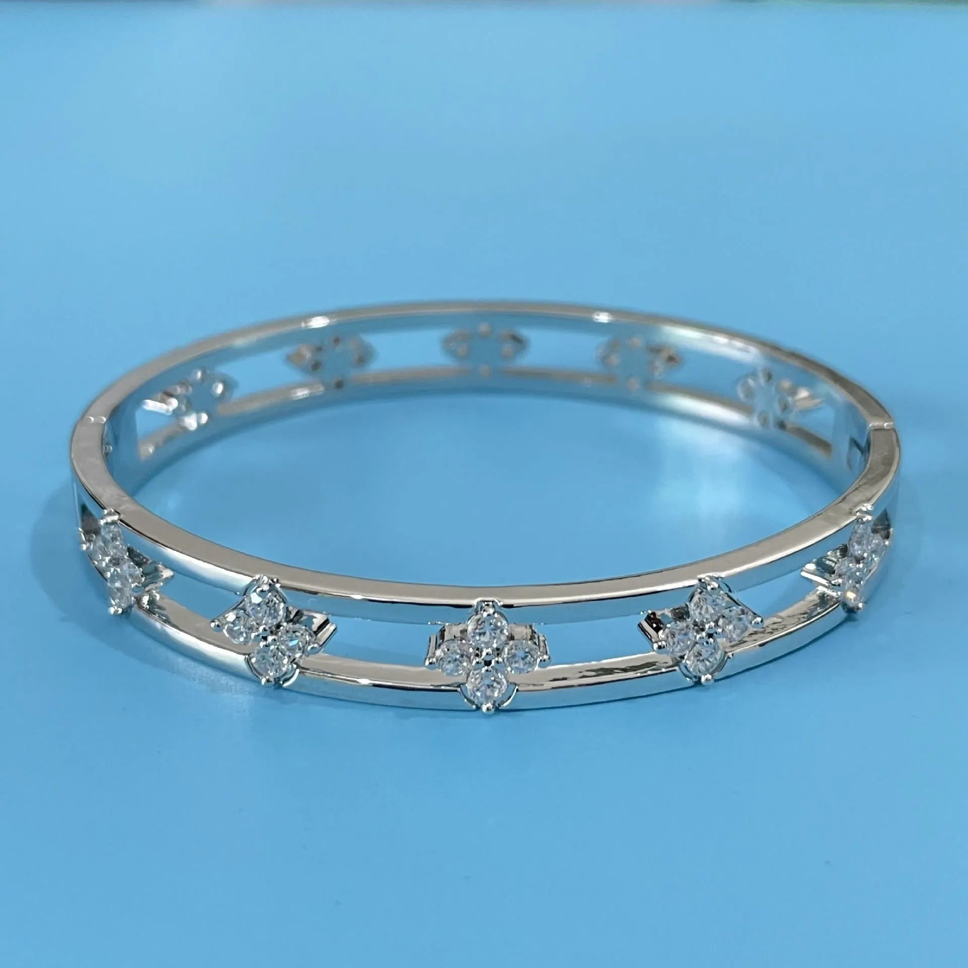 Gold and silver hollow women's bracelet with zircon four-leaf clover and grass petal charm.