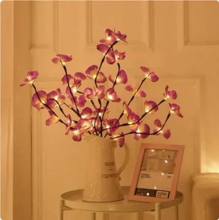 Pink phalaenopsis orchid branch decorative light with 20 LEDs, standing 65cm tall on a table.