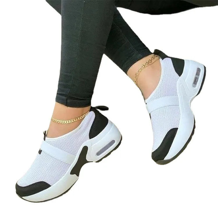 Women's flat sneakers in light grey with mesh upper, round toe, and rubber sole on a white background