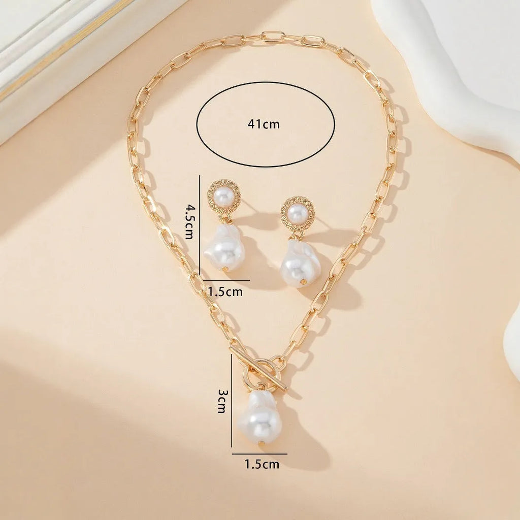 Gold-tone retro baroque necklace and earring set with a pearl pendant on an iron chain.