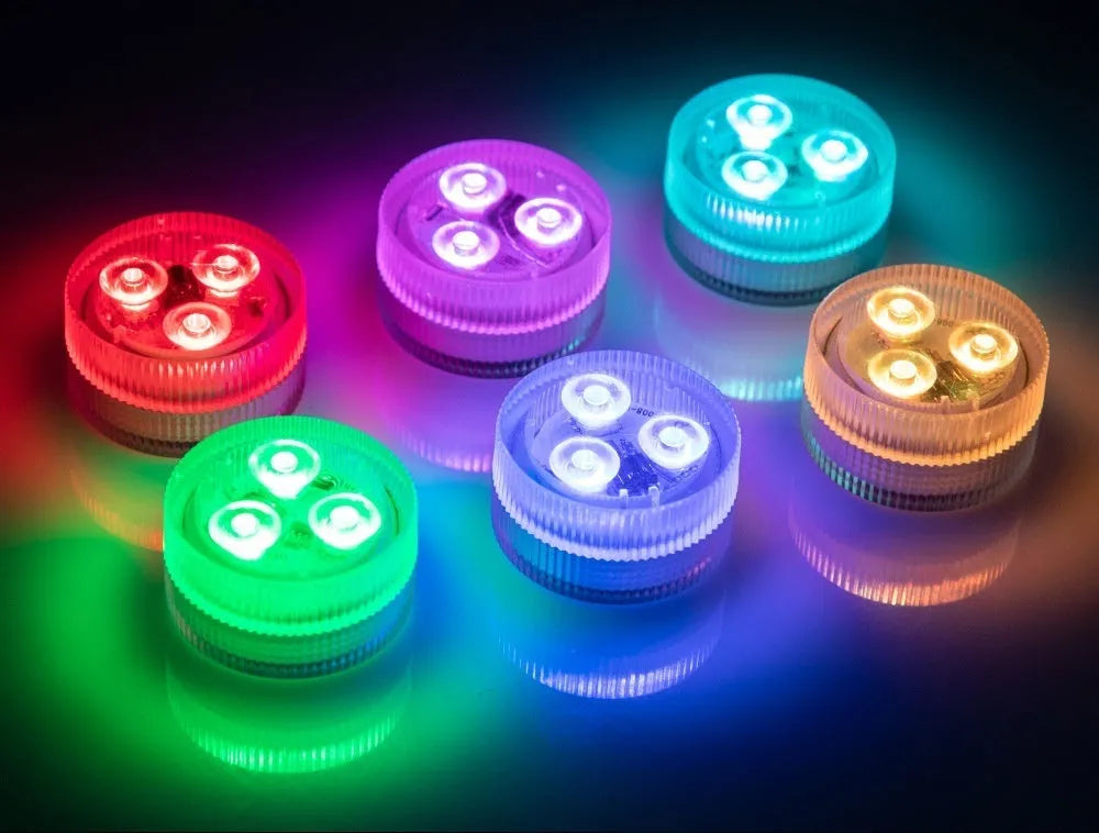 Small round remote control LED diving light for aquarium next to its multi-button remote on a table.