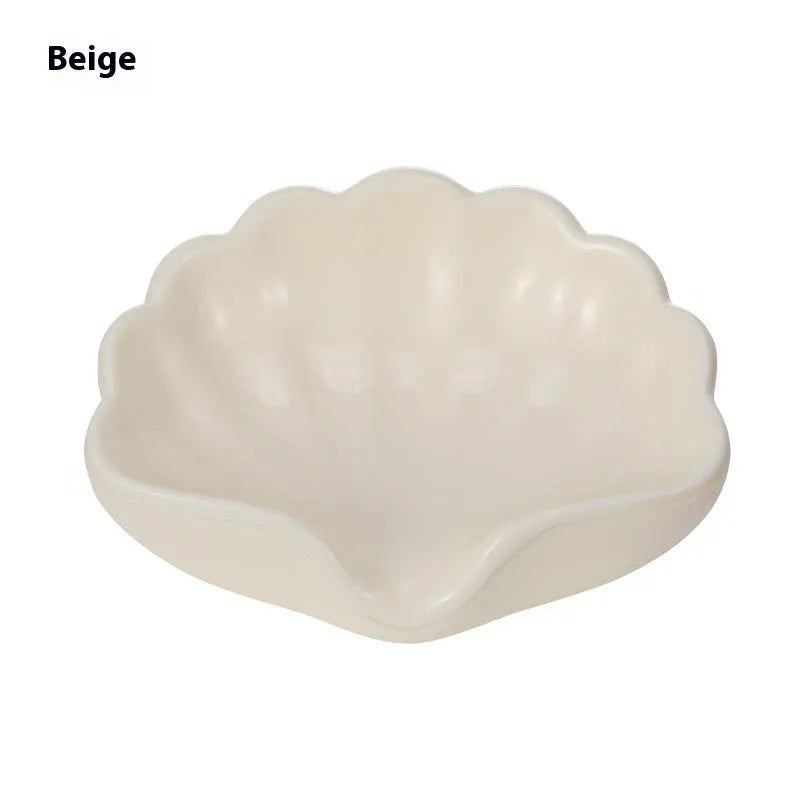White plastic shell-shaped soap dish on bathroom countertop