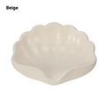 White plastic shell-shaped soap dish on bathroom countertop
