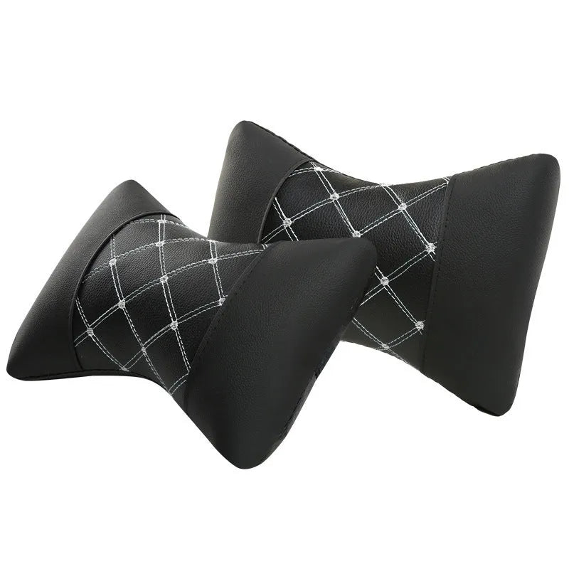 Pair of black diamond-quilted car headrest pillows with blue stitching for neck support.