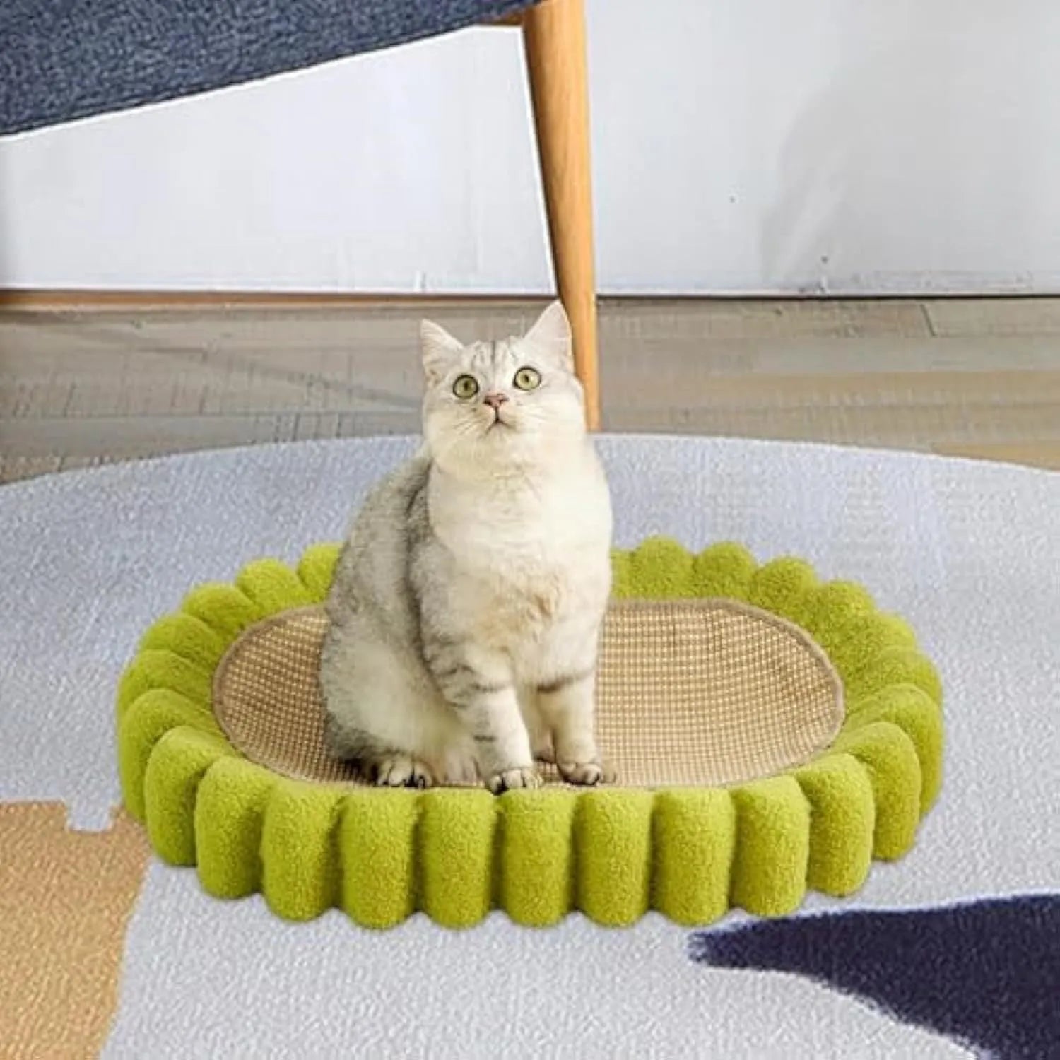 Green oval-shaped cat scratching pad serving as a bed with a sisal surface