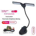 Black rechargeable music stand lamp with 28 LED bulbs lit up on a music stand.