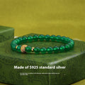 Close-up of a women's bracelet with a green agate stone on a two-tone silver and gold-plated chain.
