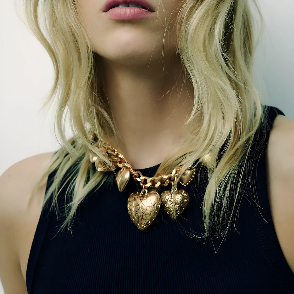Gold carved heart pendant necklace on an adjustable metal chain.
