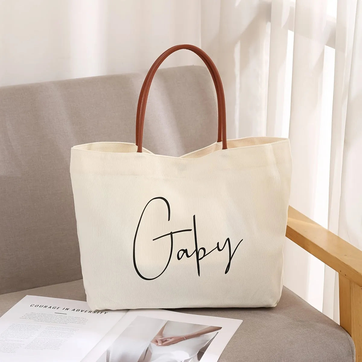 Beige white canvas tote bag with detachable crossbody strap, side bottle pockets, and a front zipped compartment.