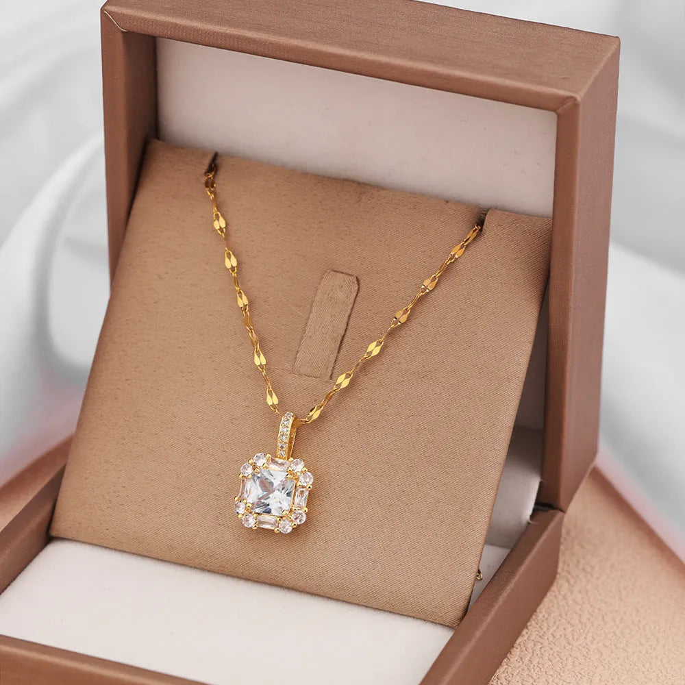 Gold geometric quadrilateral pendant necklace with gem inlay on a water wave chain.
