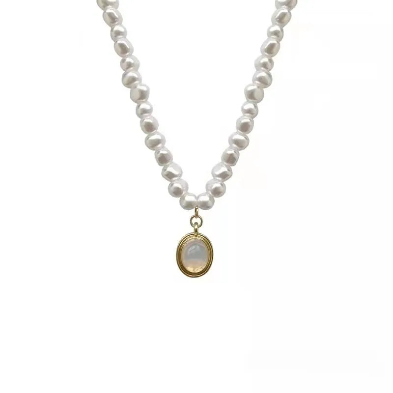 Gold electroplated adjustable vintage pearl necklace with a geometric charm on a black background.