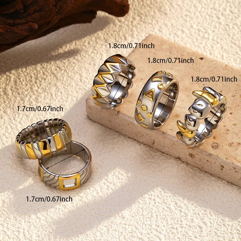 Gold and silver two-tone geometric cross stainless steel ring on a light background showing texture and electroplated finish