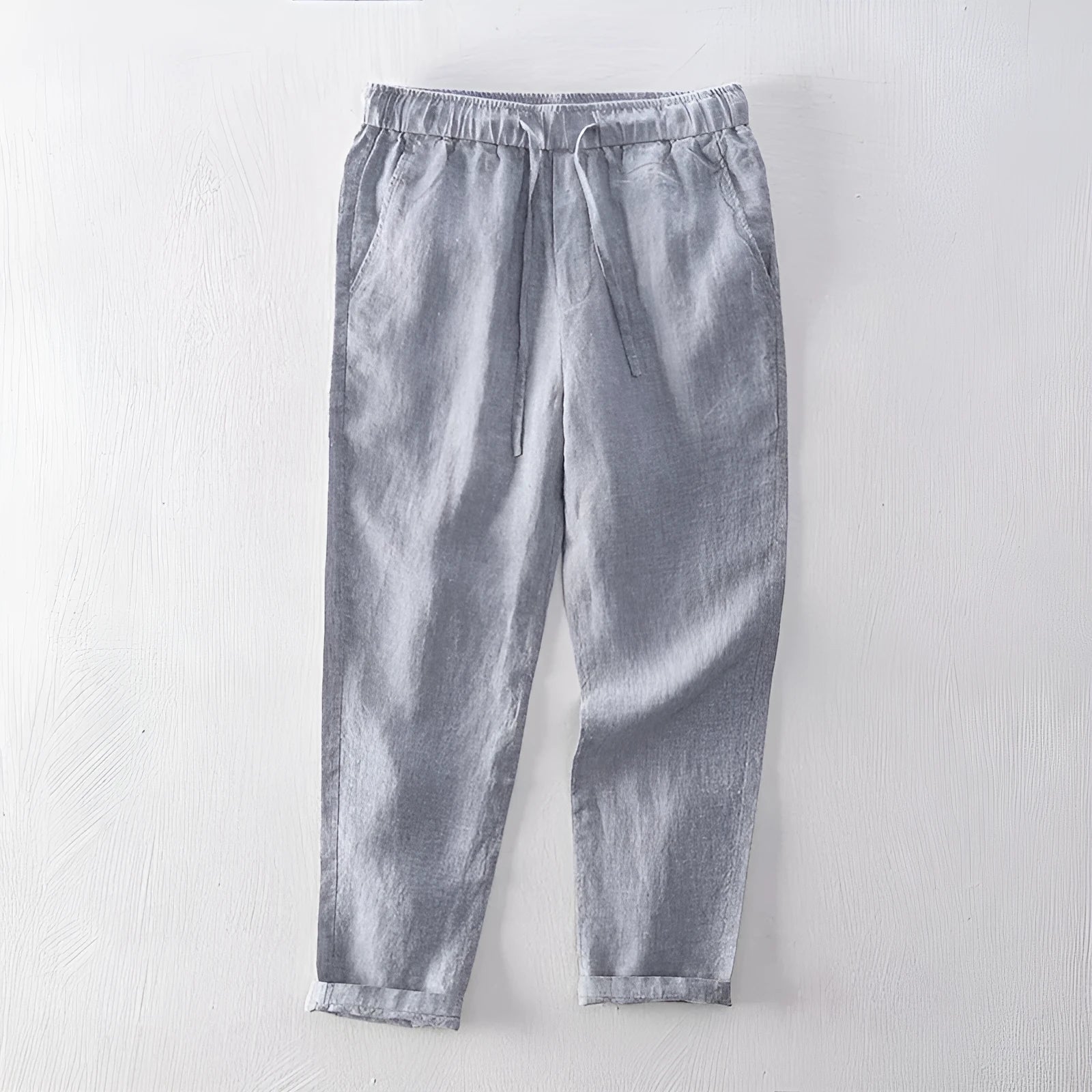 Men's straight-leg linen trousers in light grey colour showing mid-waist and straight-leg cut
