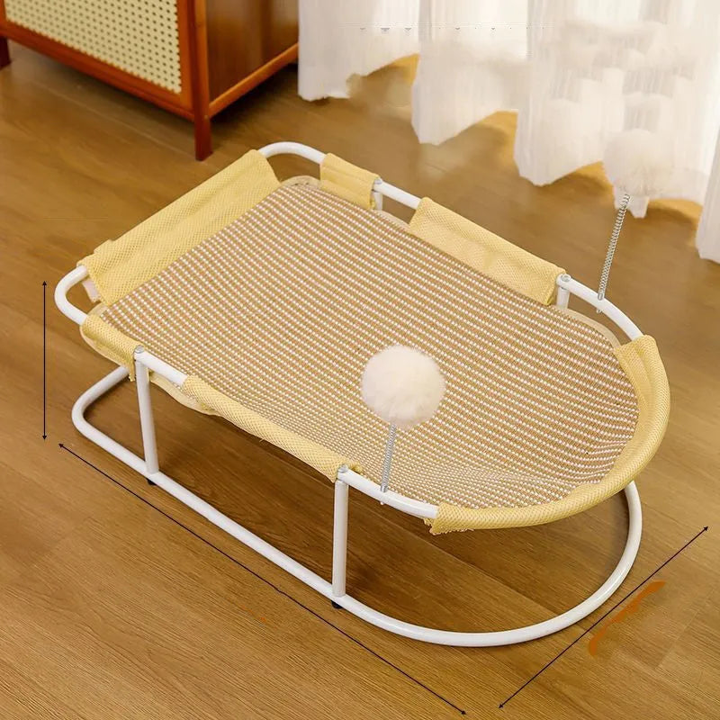 Grey fabric cat kennel with open sides and a round, removable floor pad on a carpet.