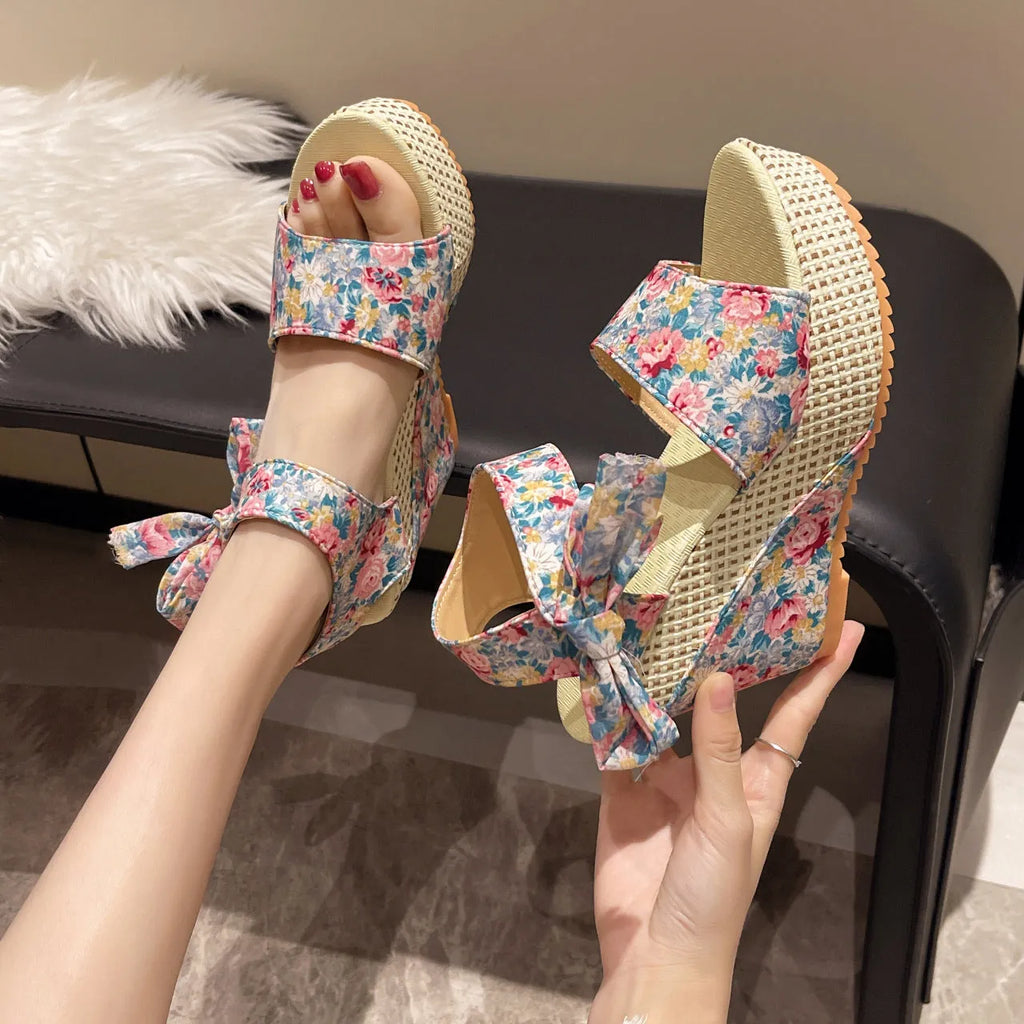 Women's floral wedge sandals with fish mouth peep toe and ankle strap buckle in pink, black, and blue patterns.