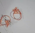Gold copper alloy stud earrings with butterfly and bow design on white background
