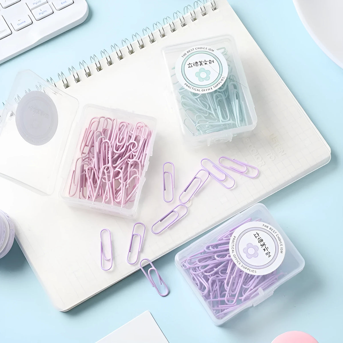 Macaron-color paper clips in pastel shades including pink, green, and purple on a white desk