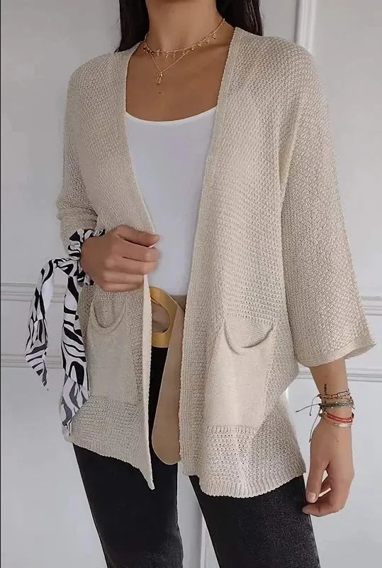 Women's army green waffle knit cardigan coat with nine-quarter sleeves and side pockets laid flat.